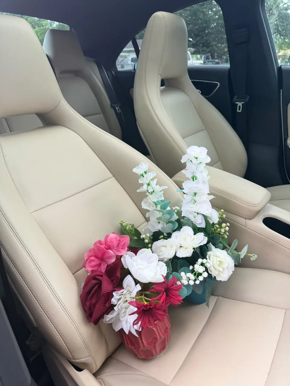 Two colorful ready-made floral arrangements in decorative pots prepared for delivery